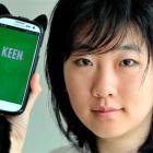 Otago University student Scout Lin (23) holds  a smartphone running a social networking...