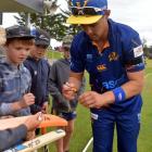 Otago Volts player Anaru Kitchen, wearing a black armband, signs autographs during the game at...
