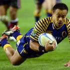 Otago winger Buxton Popoali'i launches himself over the tryline to score during the first half of...