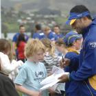 Otago winger Fetu'u Vainikolo signs an autograph for Port Chalmers School year 5 pupil Ben...