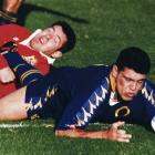Otago winger Paul Cooke scores one of his two tries against the Lions at Carisbrook. The defender...