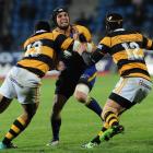 Otago winger Ryan Shortland is tackled by Taranaki midfielders George Pisi (left) and Jayden...