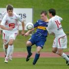 Otago United's Matt Stares (centre) competes for the ball with Waitakere's Tim Myers (left) and...