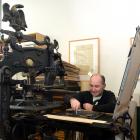 Otakou Press printer in residence Peter Vangioni works on the Columbian Eagle press in the...
