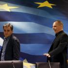 Outgoing Greek Finance Minister Yanis Varoufakis (right) shows newly appointed Finance Minister...