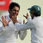 Pakistan spinner Saeed Ajmal, left, is congratulated by teammate Umar Akmal after bowling out...