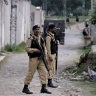 Pakistani army troops guard the perimeter of the walled compound of a house where Osama bin Laden...