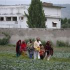 Pakistani family members leave the area after viewing the walled compound of a house, seen in...