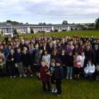 Past and present pupils, parents and staff gather around (from left) Luke Walker (7), Patrick...