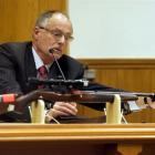 Pathologist Alexander Dempster shows where blood was found on the murder weapon, during the...