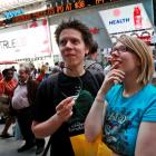 People gather outside the NASDAQ Marketsite waiting to see Facebook's share prices posted inside...