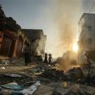 People walk through fire and rubble in the market area in Port-au-Prince, Monday, Jan. 18, 2010....