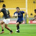 Peter Breen of Otago runs at Matt Proctor (left) and Jonny Bentley of Wellington during the ITM...