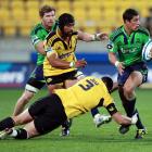 Phil Burleigh of the Highlanders is tackled by Jeffery Toomaga-Allan and Victor Vito (L) of the...