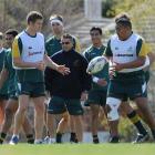 Phil Kite (centre) passes the ball to team-mate Lindsay Crook as skills coach Andy Clark (wearing...