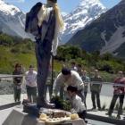 Phurenje and Edmund Sherpa lay a wreath at the base of a statue of Sir Edmund Hillary at Aoraki...