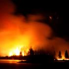 Pine trees on Motuariki Island in Lake Tekapo burn through the night as  fire engulfs the Doc...