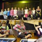 Playing guitars in front (from left) are William Archer (11), Ben Rekittke (10), Eliza Booth (11)...