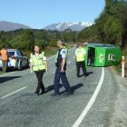 Police and ambulance staff inspect the site of a crash on the Queenstown-Glenorchy road this...