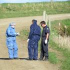 Police collect evidence from  the driveway at the home of alleged  murder victim Justin McFarlane...