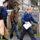 Police escort an arrested man from a Mosgiel house during a police drugs operation yesterday...