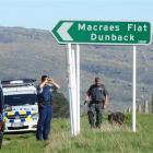 Police officers search for three teenagers near Hyde yesterday. Photo by Craig Baxter.