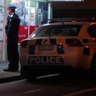 Police outside a dairy during a Kronic sting last night. Photo by Jane Dawber.