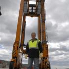 Port Otago cargo handler Harry Harrington is dwarfed by a 14m-tall Kalmar straddle crane recently...