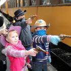 Practising their bandit apprehension skills before boarding the Taieri Gorge train yesterday are ...