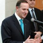 Prime Minister John Key, flanked by Fisher and Paykel Appliances' chief executive John Bongard,...