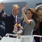 Prince William and Kate, the Duke and Duchess of Cambridge, wave as they board their plane as...
