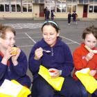 Pupils (from left) Brayden Marsh (7), Tori Bambery (10) and Kyran Marsh (5) tuck into their...