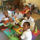 Pupils of Naviti District School with some of the books in the Otago Daily Times parcel. Photos...