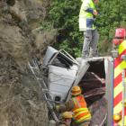 The truck, carrying a load of carpet, lies against a bank. Photos by Tracey Roxburgh.