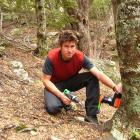 Queenstown Climbing Club committee member Philip Green installs a possum trap at Wye Creek, south...