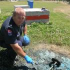 Queenstown fire safety office Stu Ide inspects the remains of a blue wheelie bin destroyed in one...