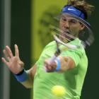 Rafael Nadal, of Spain, returns the ball to Mikhail Youzhny, of Russia, during their Qatar Open...