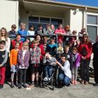 Tainui School principal Shelley Wilde (middle row, second from left) and pupils and staff are...