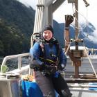 Rebecca McLeod in her drysuit before diving for samples in Fiordland. Behind her is a seafloor...