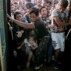 Refugees and migrants push and jostle as they try to board a bus this week  following their...