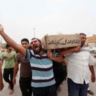 Relatives carry the coffin of an Iraqi police officer killed by militants, during a funeral in...
