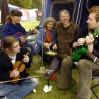 Relaxing outside their tent at last year's Whare Flat Folk Festival are (front, from right) Khris...