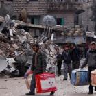 Residents evacuate their houses after being targeted by missiles fired by forces loyal to Syria's...