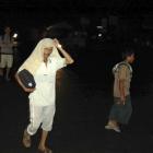 Residents flee their homes to higher ground after a strong earthquake is felt in Padang, West...