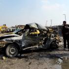 Residents gather at the site of a car bomb attack in Baghdad's Kadhimiya district. REUTERS/Thaier...