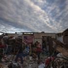 Residents walk through debris of homes after the suburb of Moore, Oklahoma was left devastated by...