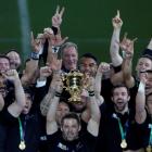 Richie McCaw holds the trophy aloft as the All Blacks celebrate winning the World Cup. Photo Reuters