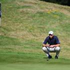 Robert Gates lines up a putt on the 17th green on day 2 of the NZ Golf Open at the Hills. Photo...