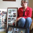 Robyn Couper with photographs of some of her Haitian friends. Photo by Sally Rae.