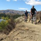 Roger (front) and Sandra Cain, of Dunedin, cycle the new section of the Clutha River Track...